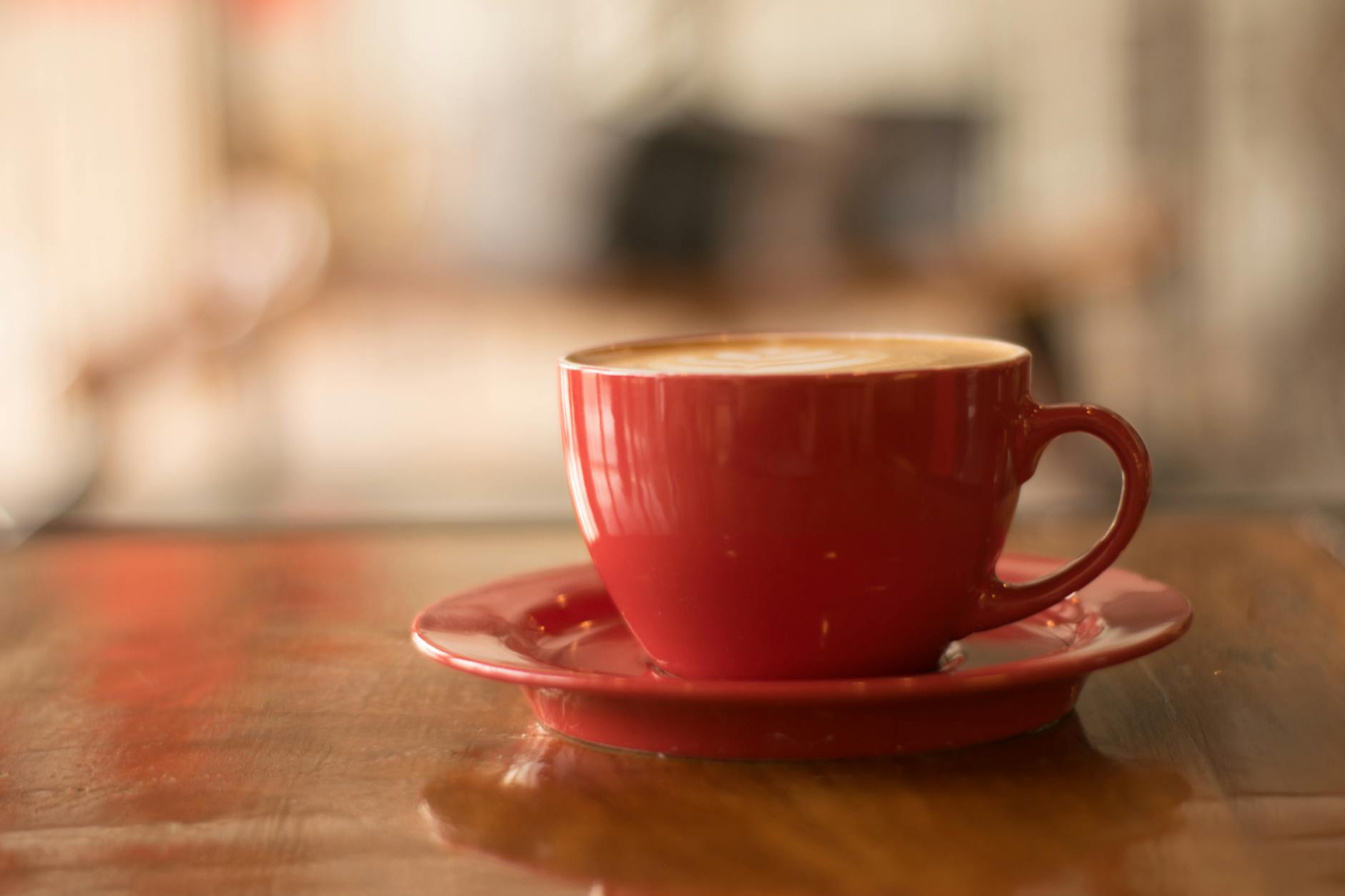 red ceramic mug on red saucer